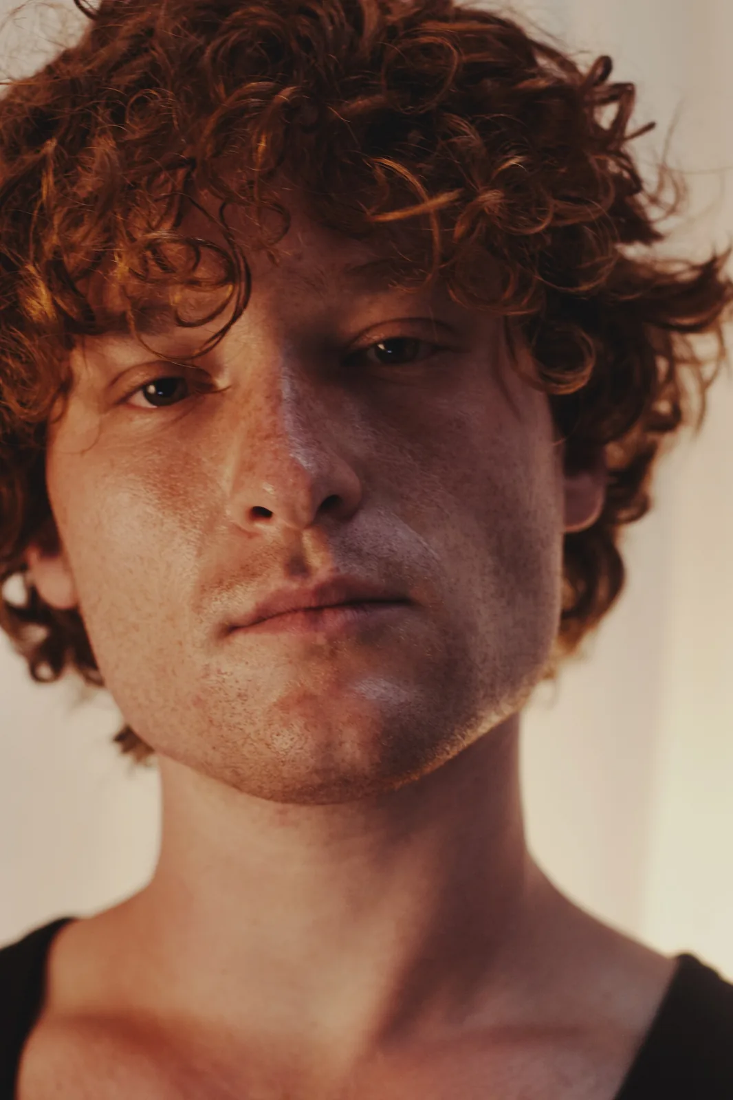 Close-up portrait in warm light, half the face in shadow